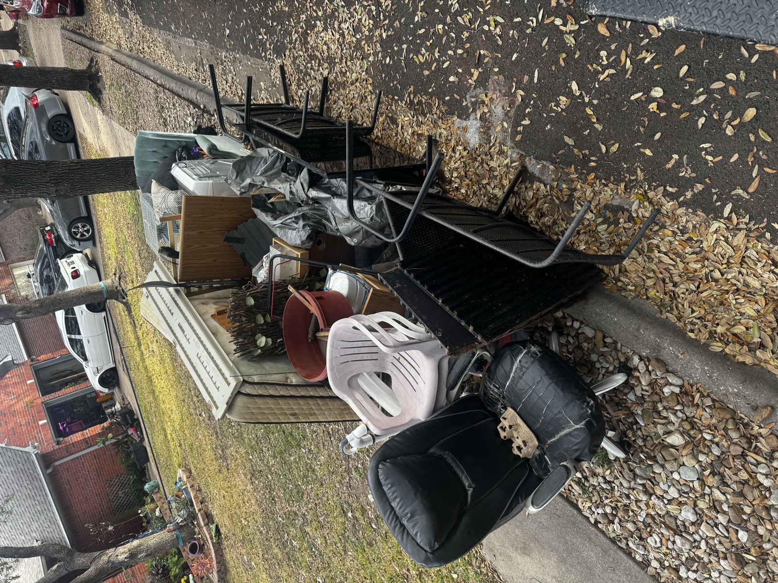 Old furniture and junk piled in a yard before removal